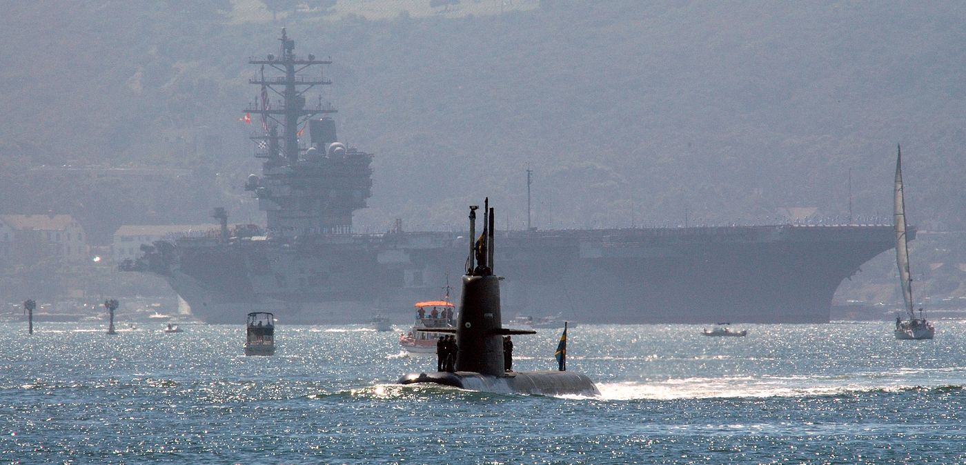 O submarino sueco Gotland navegando à frente do porta-aviões USS Ronald Reagan, em 2005.